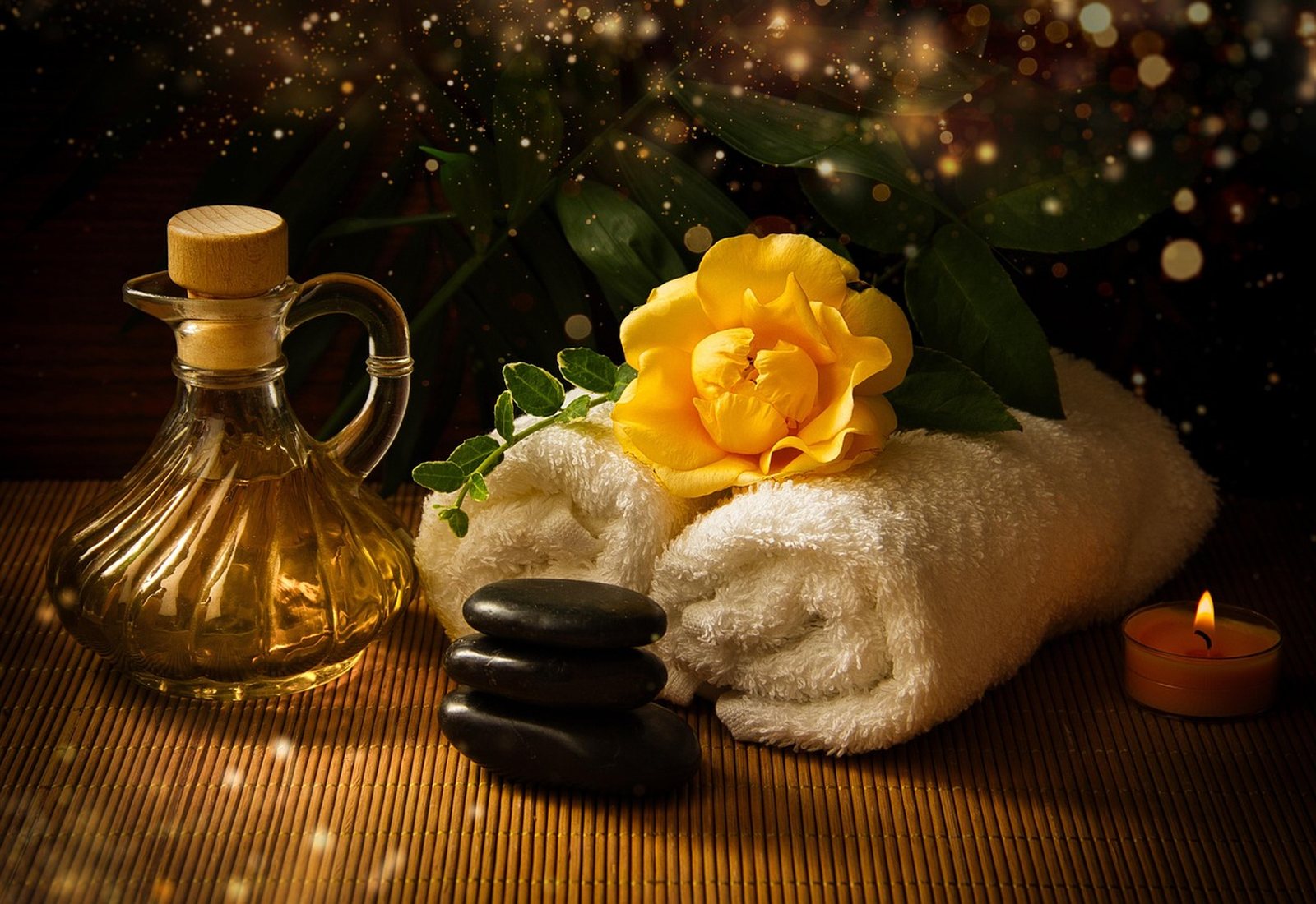 Huile de massage, fleurs et serviettes pour un soin bien-être